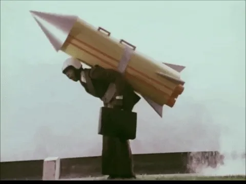 Animated GIF of a man running with a cardboard rocket strapped to his back